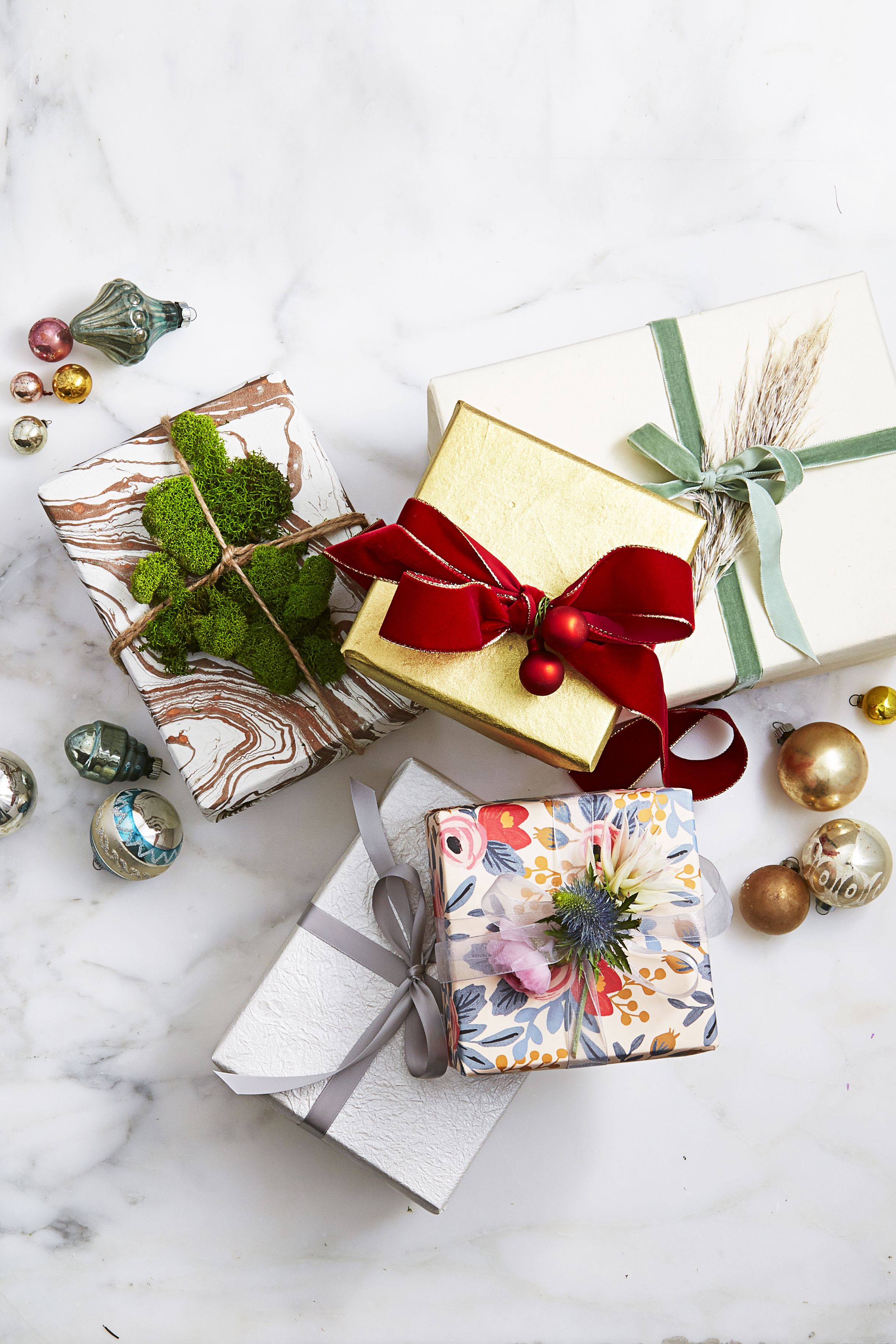 Woman Tying Gift Box In The Center Of Christmas Decorating Items On A  Wooden Table Stock Photo - Download Image Now - iStock