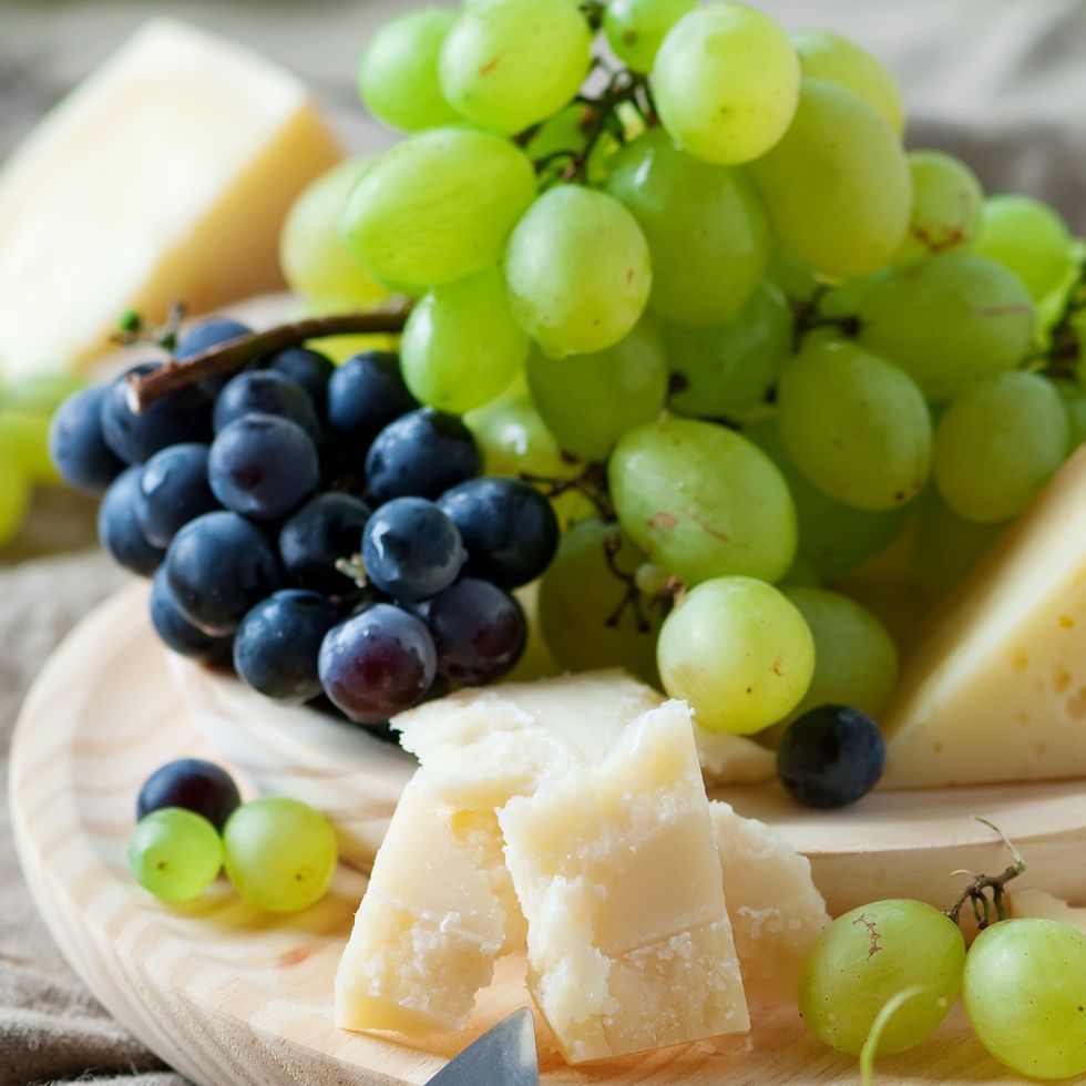 grapes and cheese on a wooden board