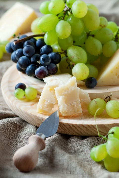 grapes and cheese on a wooden board