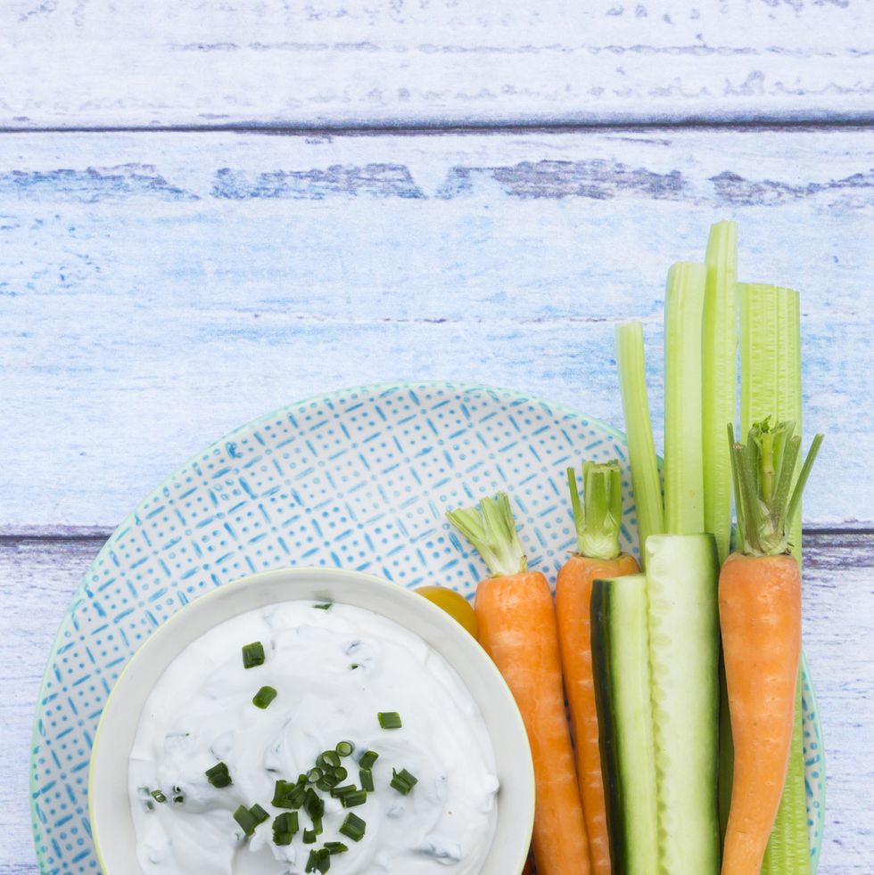 healthy cream dip with veggie sticks on a blue and white plate
