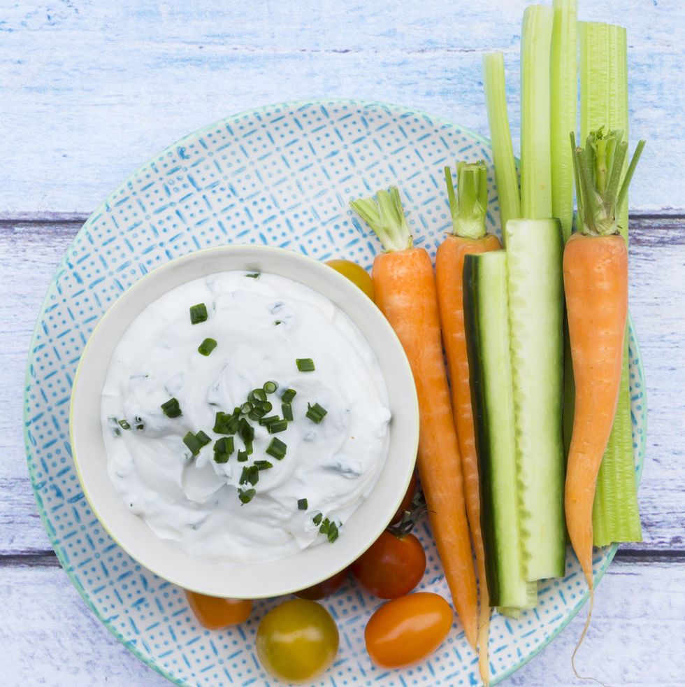 healthy cream dip with veggie sticks on a blue and white plate