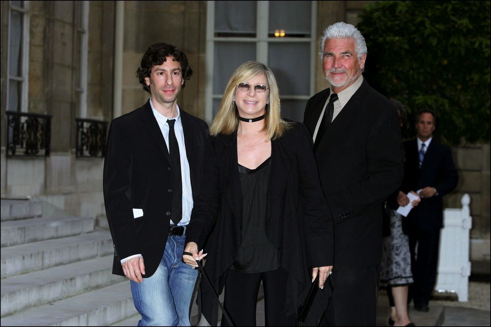 Jason Gould, Barbra Streisand, and James Brolin pose at a French ceremony to honor Streisand.