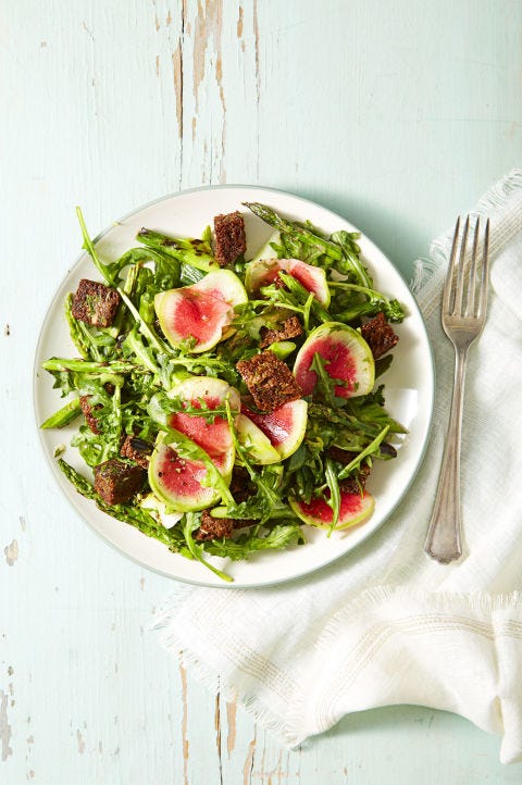a plate of garden greens and pumpernickel panzanella salad