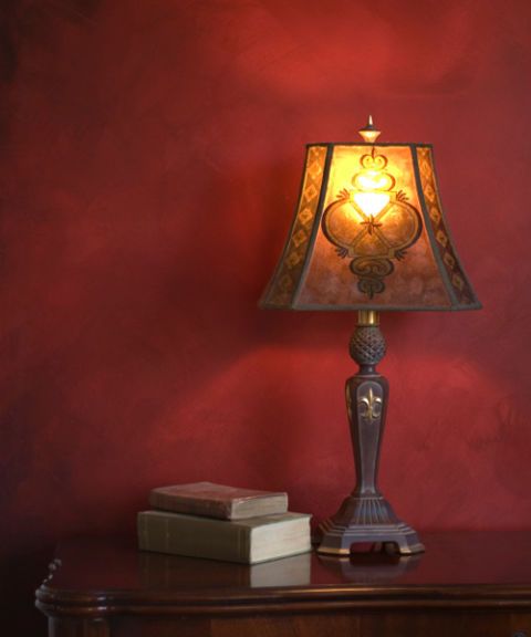 antique lamp on table with books and red wall