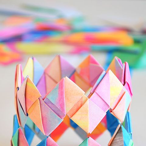 a colorful diy folded paper bracelet sits on a table the project is a good housekeeping pick for best activities for kids
