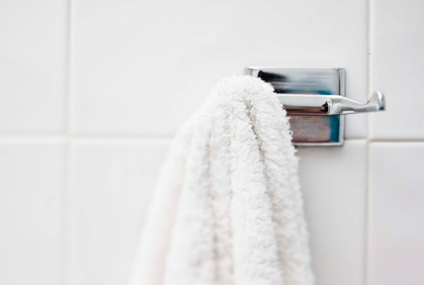 white towel hanging from a silver hook