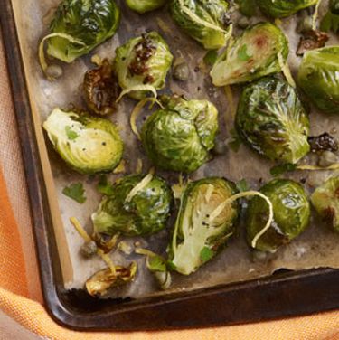 a sheet pan filled with roasted brussels sprouts and some lemon zest