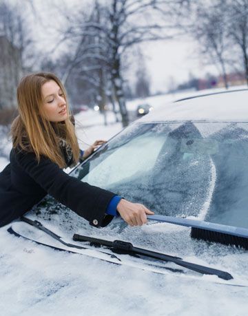 woman scraping ice off car