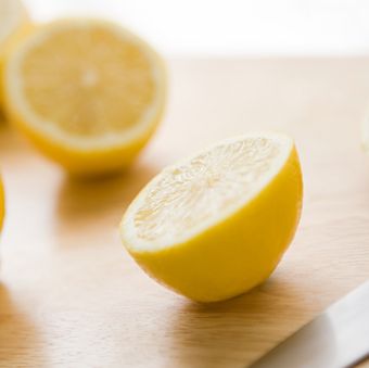 a lemon on a wooden cutting boards, an ingredient in one of good housekeeping's best homemade face scrubs