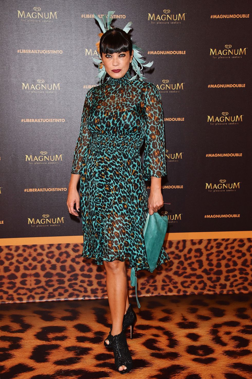 <p>Ana Laura Ribas sceglie la versione animalier in verde con un tocco frivolo, le piume in testa.</p>