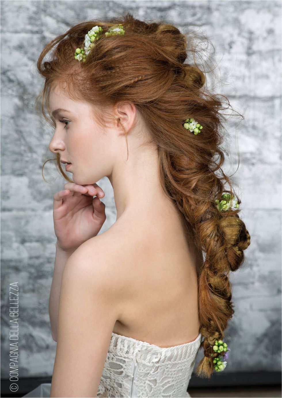 <p>I capelli sono intrecciati ad arte e si appoggiano delicatamente sulla schiena. Tra le ciocche, piccoli fiori aggiungono all'acconciatura un mood ancora più femminile.</p>