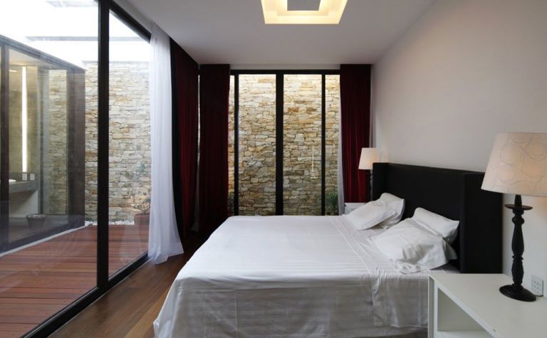 <p>The glass walls continue into the master bedroom, letting in loads of natural light.</p>
