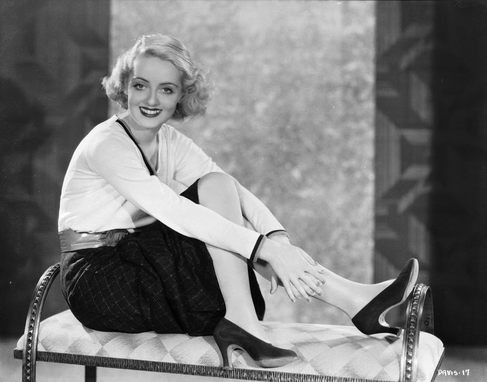 circa 1932:  American film star Bette Davis (1908 - 1989) wearing high heels and a winning smile.  (Photo via John Kobal Foundation/Getty Images)