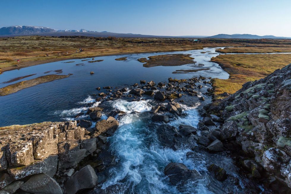 <p>Il viaggio prosegue verso<strong> Þingvellir</strong>, la zona verde e non abitata che si trova nella parte sud-occidentale dell'isola, dal 1928 è diventata Parco nazionale (<em>thingvellir.is</em>). Percorro l'<strong>Almannagjá</strong>, una stretta gola dominata da pareti di roccia vulcanica, nel punto in cui la placca tettonica americana incontra quella euroasiatica. Il belvedere di <strong>Hakið</strong>, vicino al centro visitatori, offre la vista su vallate e corsi d'acqua. Si radunò qui, nel 930, il primo parlamento democratico del mondo, proclamando la nascita dello stato libero d'Islanda. Dal Lögberg, la Roccia della Legge, si poteva parlare, grazie alla straordinaria acustica naturale, a migliaia di persone. Si prendevano decisioni d'importanza nazionale (come quella sulla conversione al Cristianesimo nell'anno 1.000), si concordavano matrimoni, si facevano affari e si attuavano feroci esecuzioni. </p>