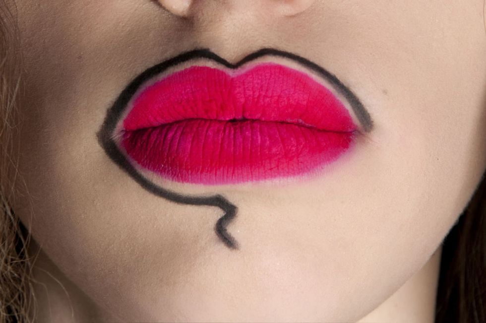 <p>Una linea tracciata con la matita nera, circonda le labbra truccate con un rossetto color geranio mat.</p>