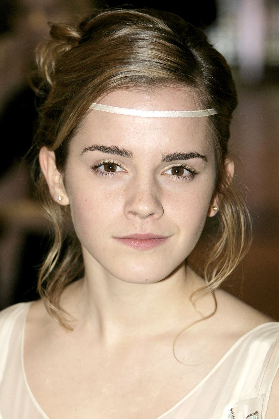 <p>Watson has always had a love for headbands. Here, she wears an ivory one across her forehead.</p>