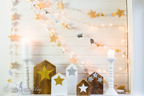 <p>Usa legno di recupero per creare il tuo piccolo villaggio natalizio, poi ritaglia tante stelle colorate di carta e cucile su fili di lucine natalizie.</p><p>(<a href="http://www.songbirdblog.com/garlands-stars-houses-christmas-mantel/" target="_blank">Song Bird Blog</a>). </p>