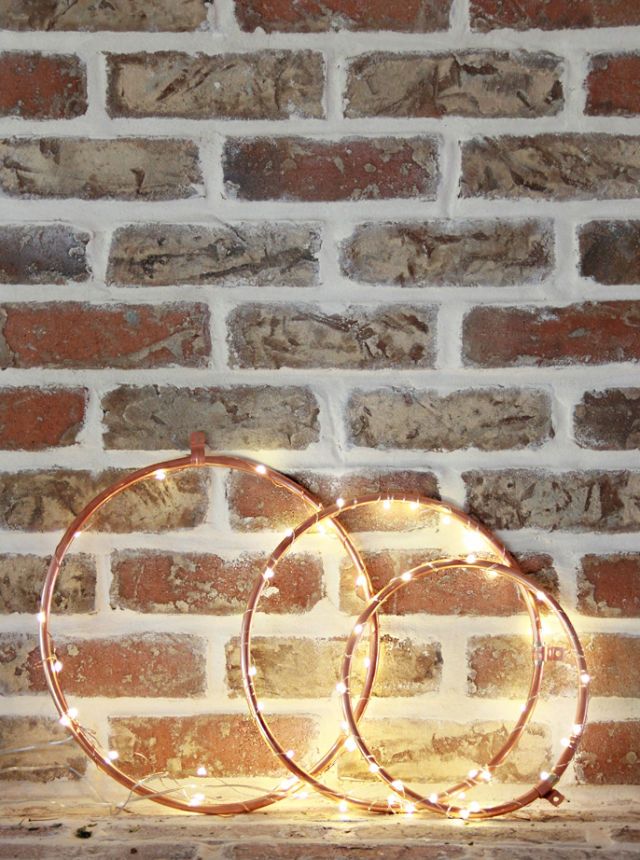 <p>Questa decorazione semplice e minimal può sostituire la classica ghirlanda natalizia: crea un cerchio con fil di ferro o di rame, avvolgi con luci di Natale e il gioco è fatto.</p><p>(<a href="http://www.abubblylife.com/2015/11/diy-copper-lighted-wreaths.html" target="_blank">A Bubbly Life</a>).</p>