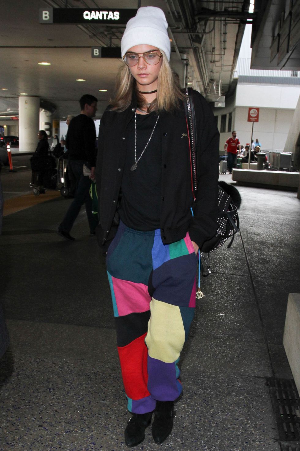 <p>Arriva all'aeroporto di Los Angeles con un pantalone patchwork multicolor, occhiali da sole oversize e cappello beanie.&nbsp;</p>
