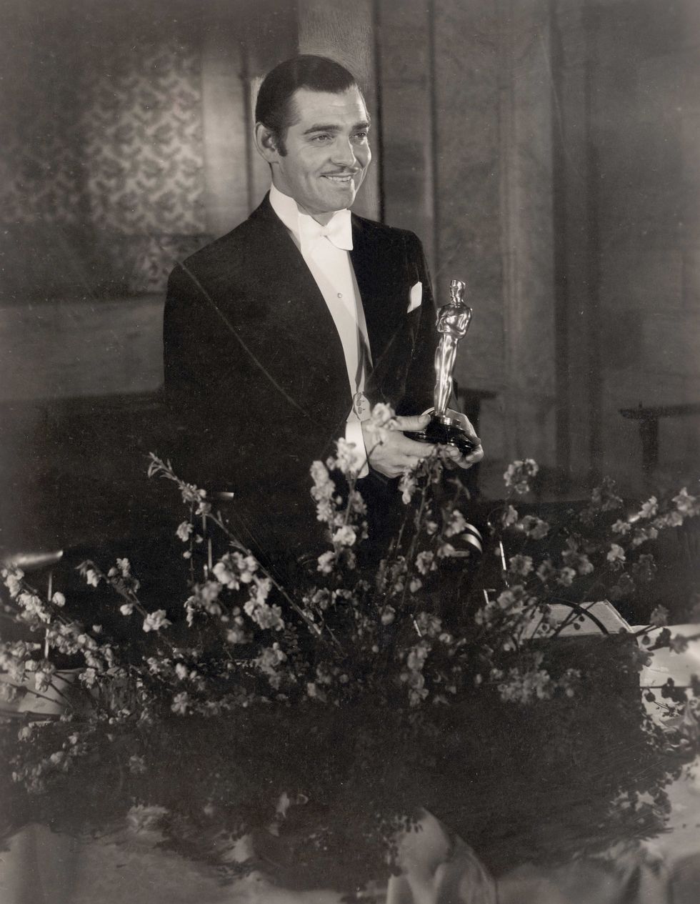 <p>Clark Gable, dapper in white tie and tails, picks up the Best Actor award for <i data-redactor-tag="i">It Happened One Night</i>. The film also won Best Actress for Claudette Colbert, Best Director for <a href="http://www.townandcountrymag.com/leisure/arts-and-culture/news/a8963/its-a-wonderful-life-christmas/" target="_blank" data-tracking-id="recirc-text-link">Frank Capra</a>, and Outstanding Production.<span class="redactor-invisible-space" data-verified="redactor" data-redactor-tag="span" data-redactor-class="redactor-invisible-space"></span></p>