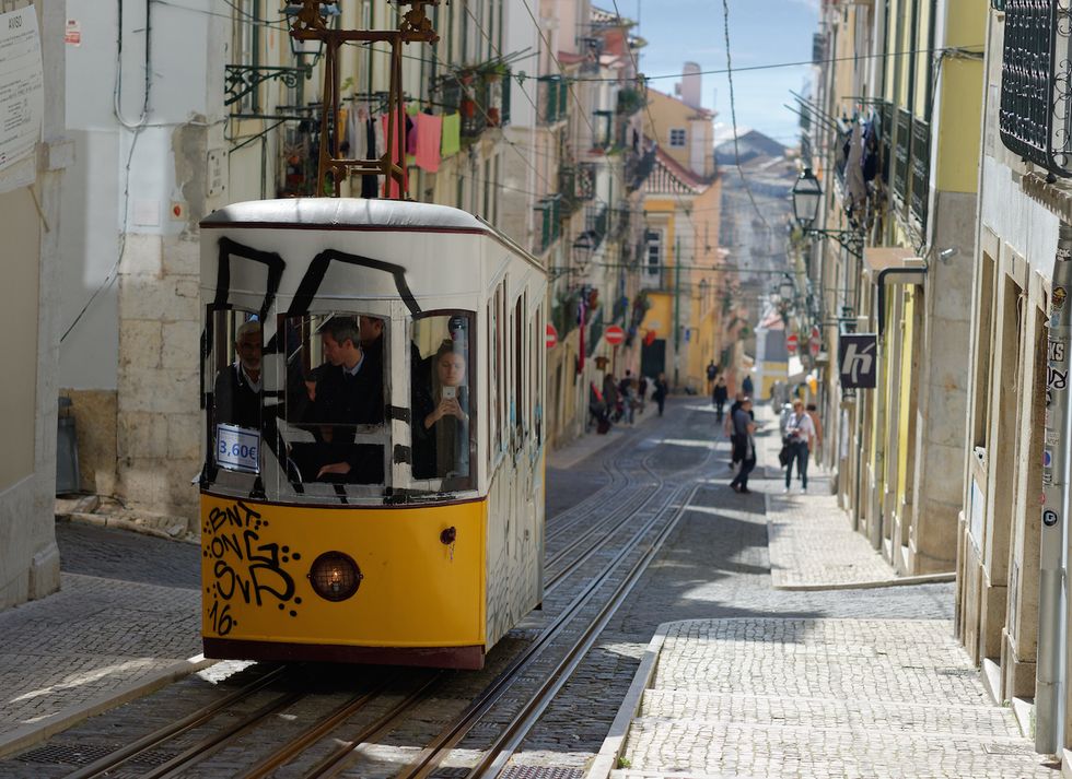 Transport, Mode of transport, Vehicle, Tram, Yellow, Town, Street, Rolling stock, Urban area, Cable car, 