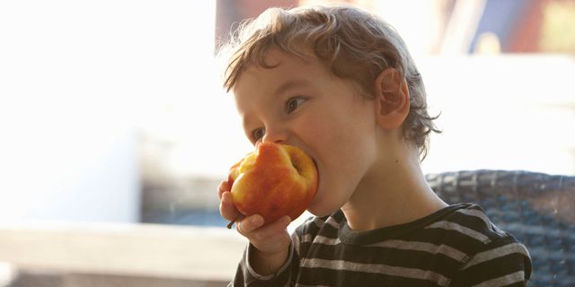 Un bambino mangia una mela
