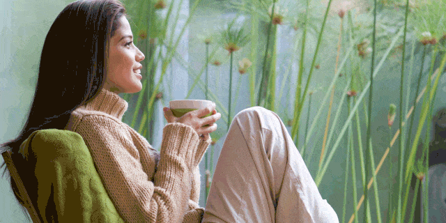 Comfort, Human body, Sitting, Coffee cup, Drink, Knee, Outdoor furniture, Lap, Sweater, Aquatic plant, 