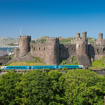 Rolling stock, Railway, Wall, Landmark, Train, Railroad car, Castle, Locomotive, History, Medieval architecture, 