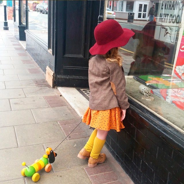Yellow, Hat, Fashion accessory, Street fashion, Bag, Toy, Sidewalk, Snapshot, Sun hat, Door, 