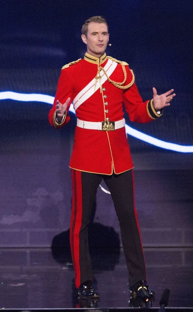 Standing, Artist, Performance, Electric blue, Suit trousers, Costume design, Costume, Fashion design, Talent show, Belt, 