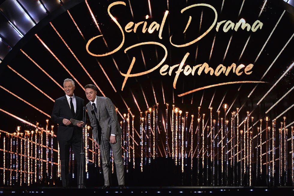 Text, Suit, Darkness, Suit trousers, Midnight, Stage, Electronic signage, Calligraphy, Tuxedo, 