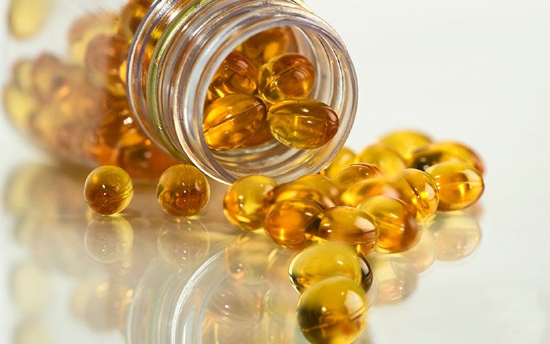 Dietary supplement, Yellow, Amber, Capsule, Cod liver oil, Amber, Food, Fish oil, Caramel color, Glass, 