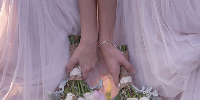 Dress, Bouquet, Wedding dress, Bride, Pink, Bridal clothing, Hand, Flower, Bridal accessory, Bridal party dress, 