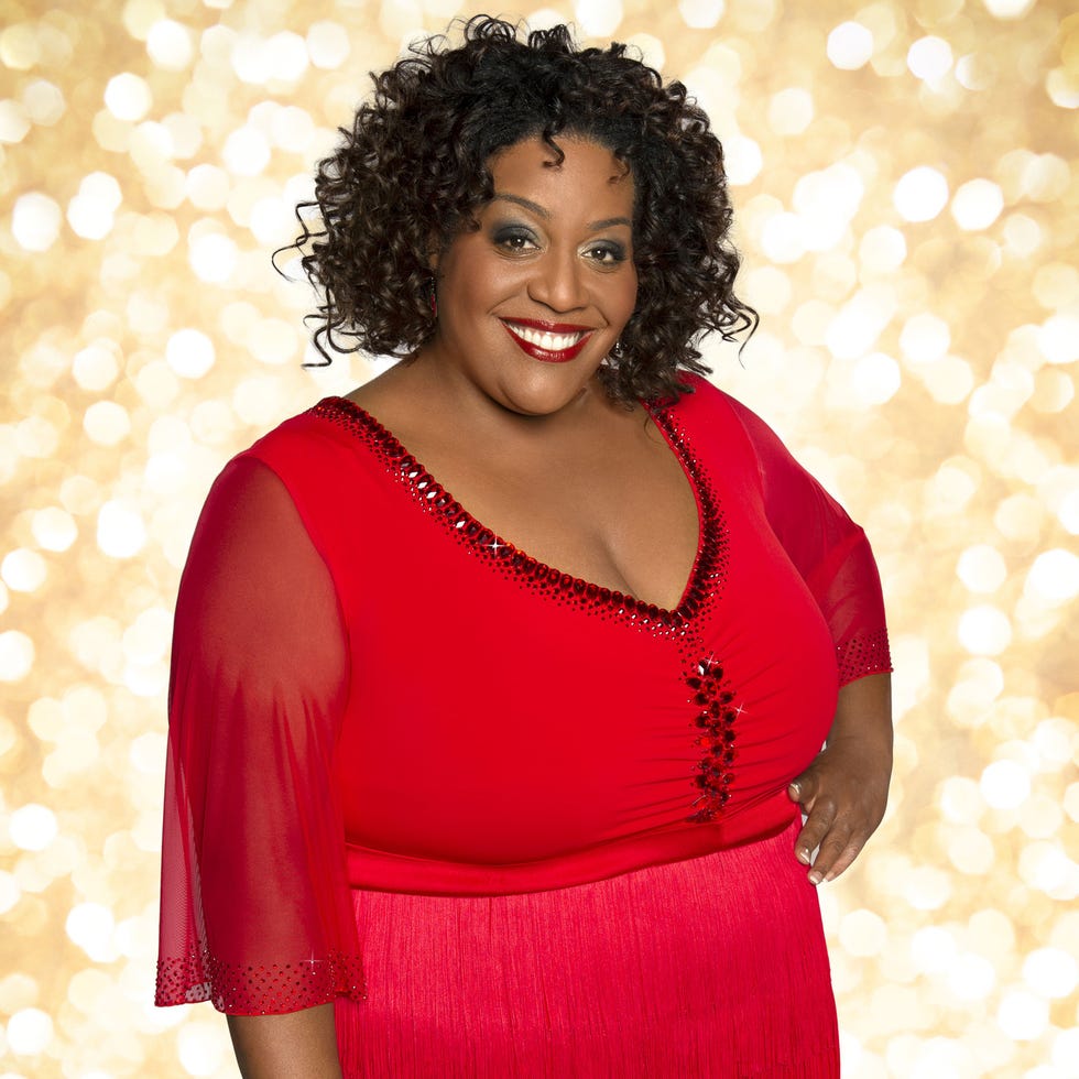 Jheri curl, Hairstyle, Shoulder, Red, Ringlet, Facial expression, Style, Jewellery, Dress, Black hair, 