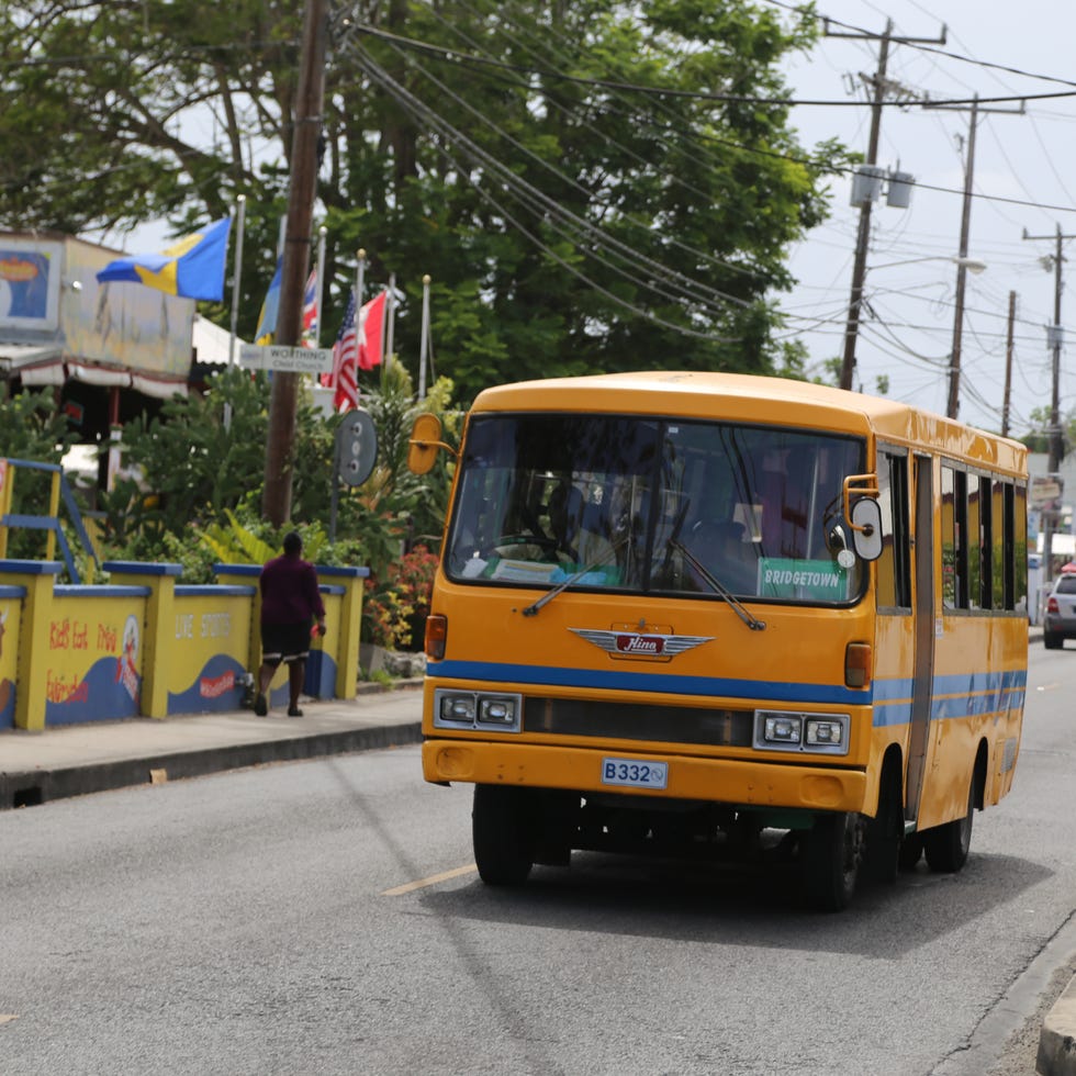 Motor vehicle, Mode of transport, Transport, Bus, Automotive parking light, Commercial vehicle, Public space, Windscreen wiper, Asphalt, Overhead power line, 