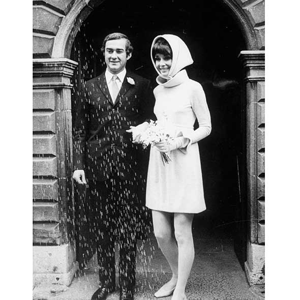 Photograph, Coat, Standing, Dress, Formal wear, Style, Monochrome, Vintage clothing, Arch, Monochrome photography, 