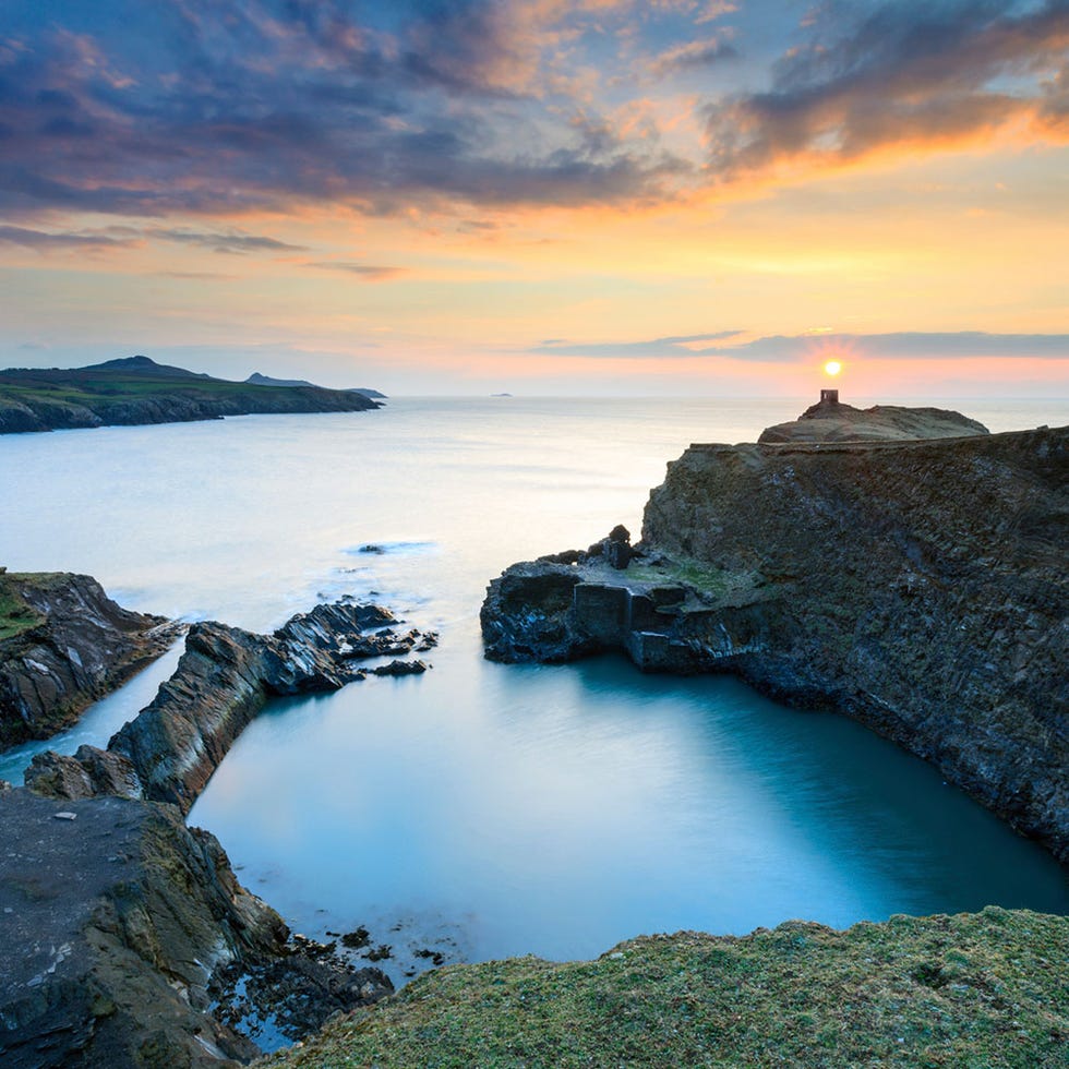 Body of water, Natural landscape, Cloud, Coastal and oceanic landforms, Water resources, Sunset, Dusk, Rock, Horizon, Coast, 