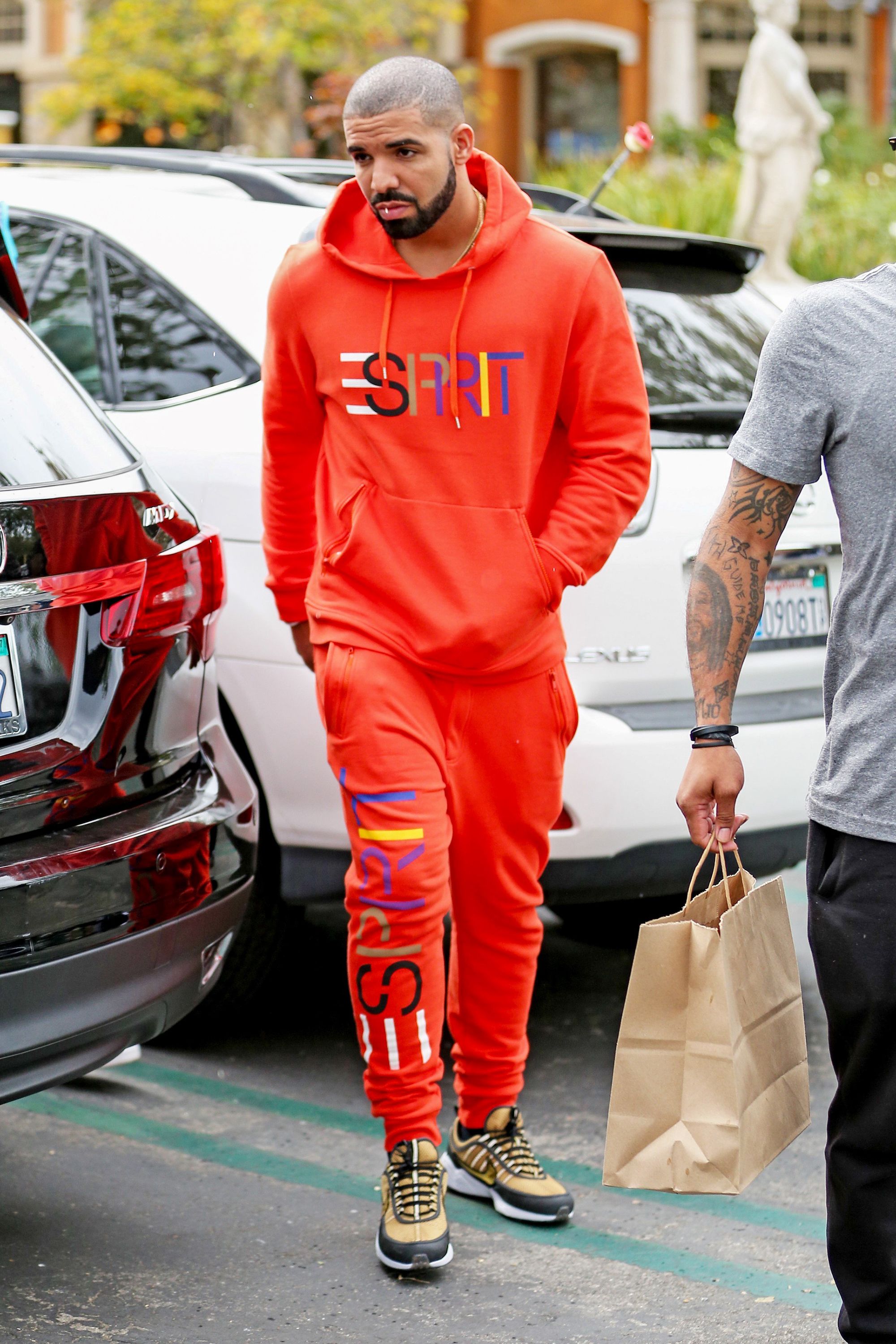 Does anyone know what designer brand Drake's tracksuit is? The piping on  the zipper and seam of the pants are the same. I just can't make out what  the logo is on