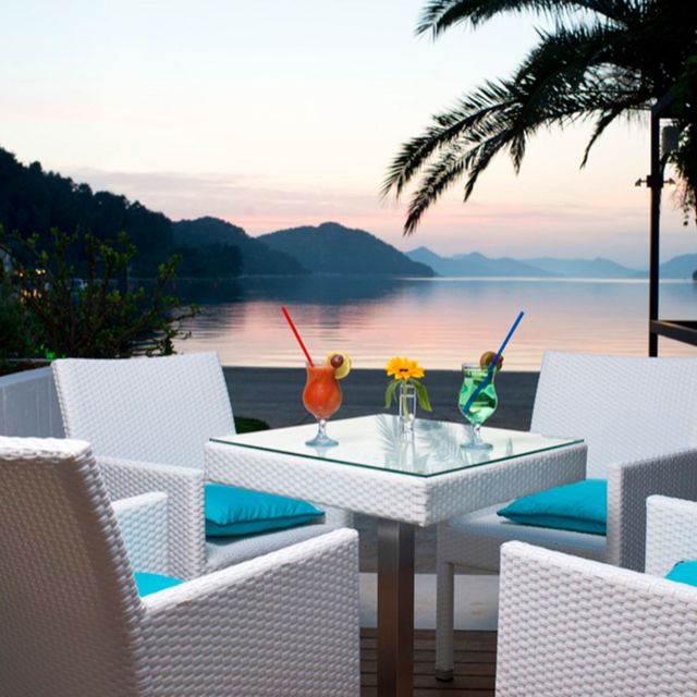 Table, Furniture, Outdoor furniture, Outdoor table, Resort, Coastal and oceanic landforms, Chair, Restaurant, Ocean, Tropics, 