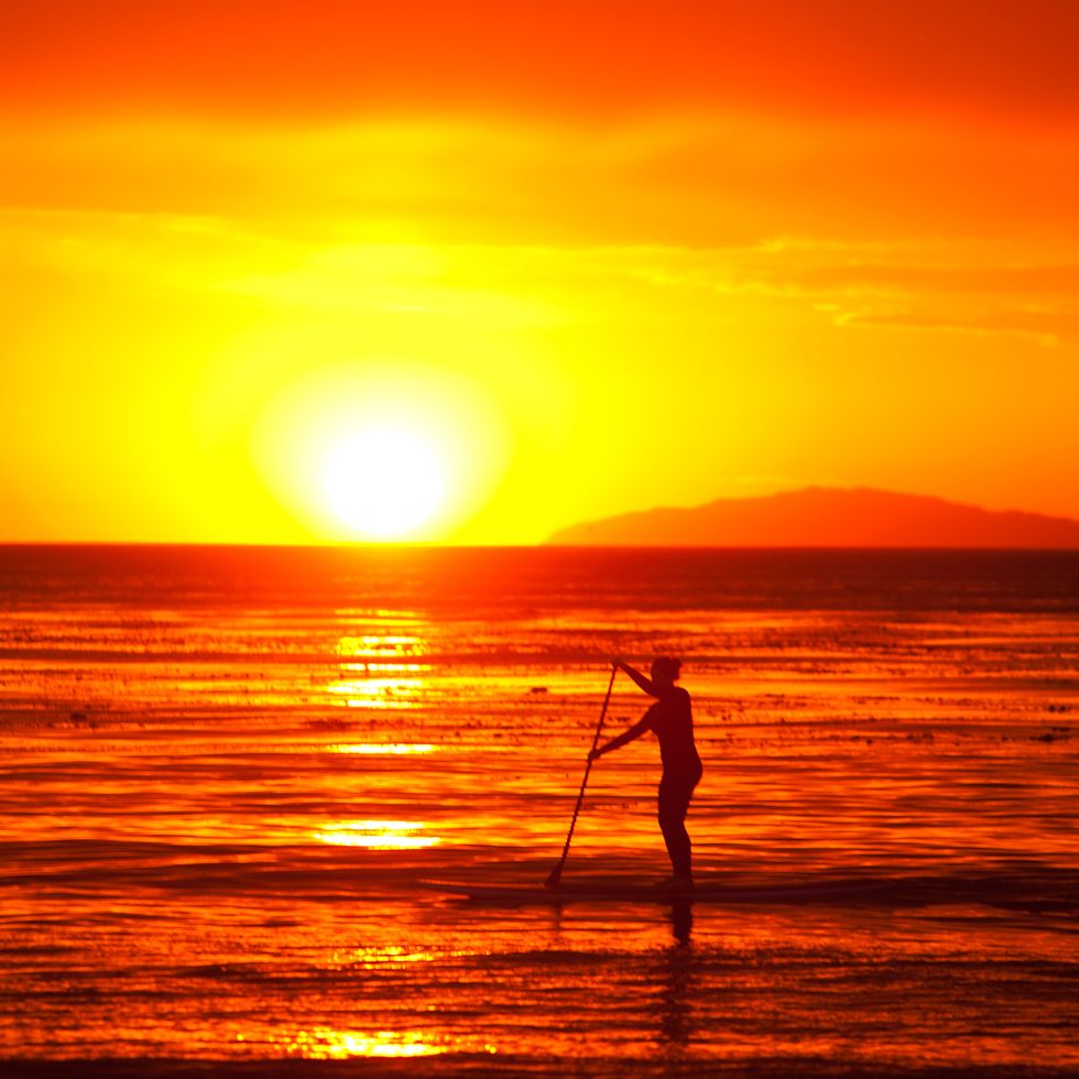 Stand-up paddleboarding at sunset