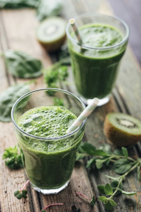 Green vegetable and fruit smoothie with spinach, salad, parsley, cress, oregano and kiwi