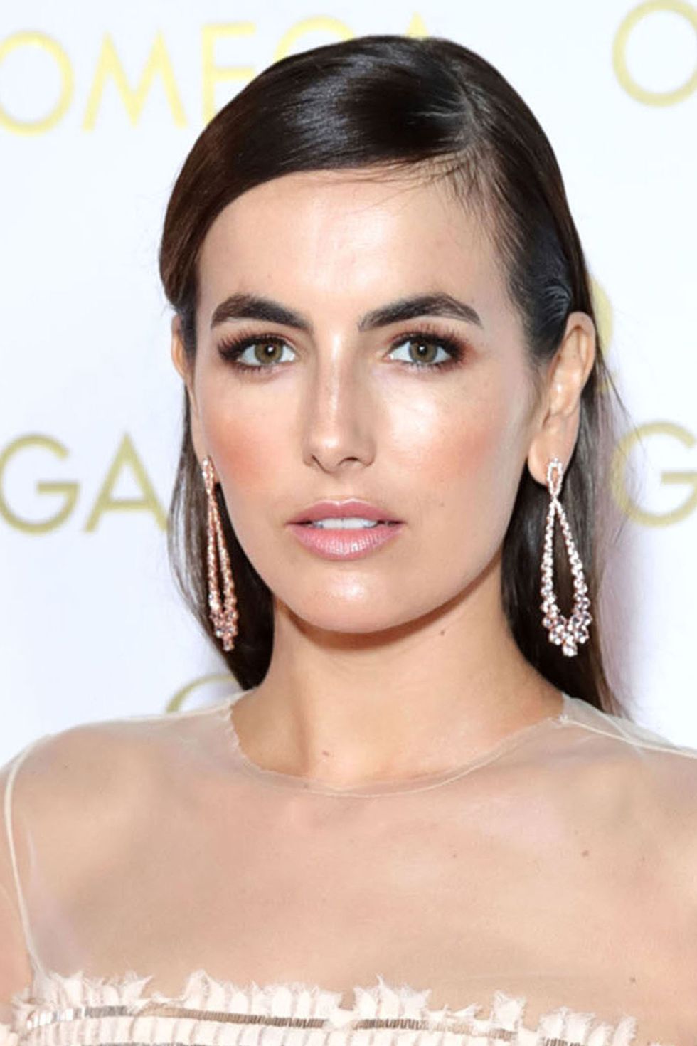 Camilla Belle sleeked back hair and pink lips and glowing skin