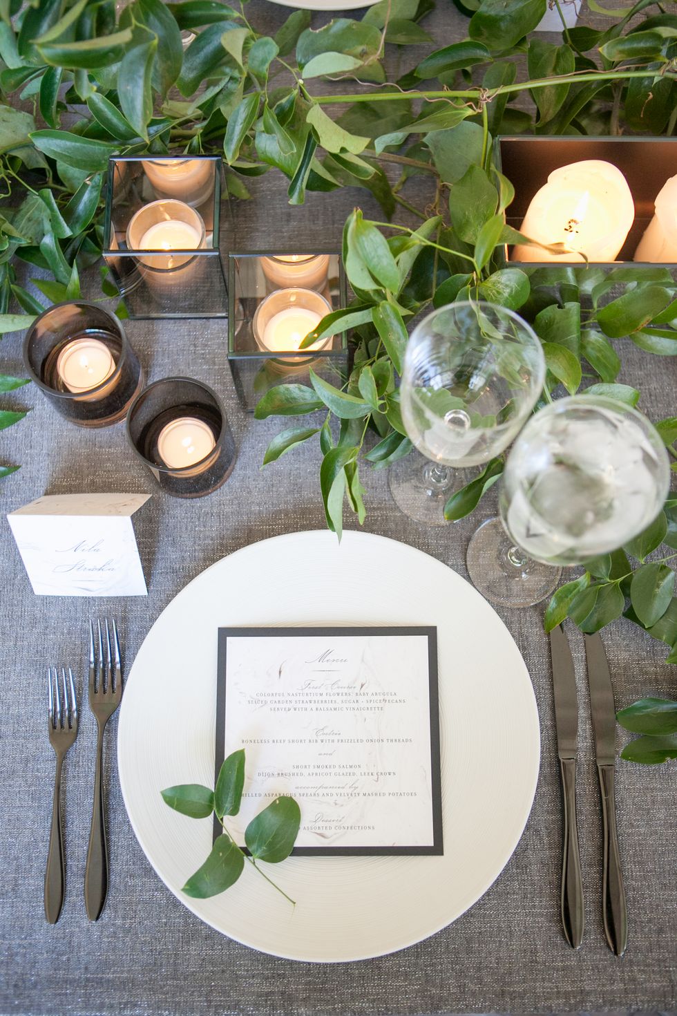 <p><a href="http://www.paperzest.com/" target="_blank" tabindex="-1">Paperzest</a> created the marble-themed menus, which rested on top of white dinner plates that were decorated with a small sprig of greenery.</p>