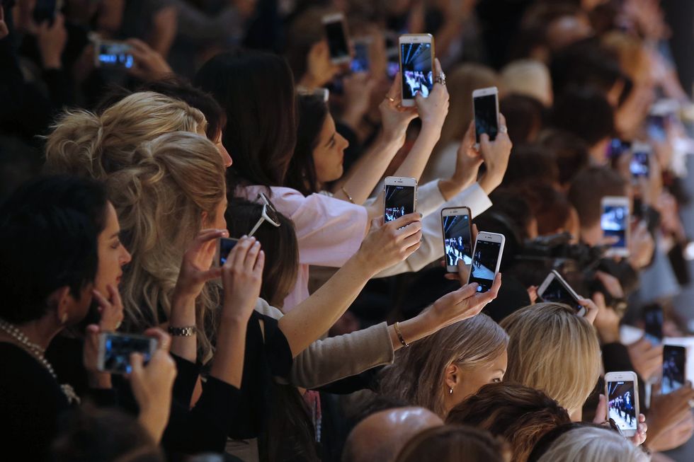 Hair, Camera, Crowd, Hand, Audience, Mobile phone, Cameras & optics, Gadget, Jewellery, Portable communications device, 