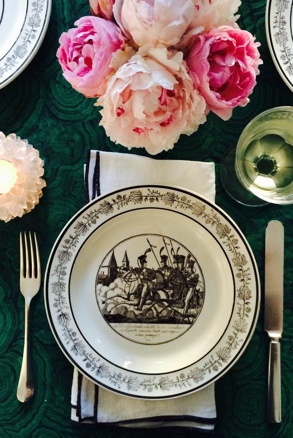 <p>And in focusing on the table, feel free to deviate from the standard red-and-green. "Rather than the traditional red and green scheme, try something new like a fabric in malachite and hot pink peonies," says designer <a href="http://grantkgibson.com" target="_blank">Grant Gibson</a>. "Layer in black and white for a graphic pop. The plates [here] are antique French."</p>