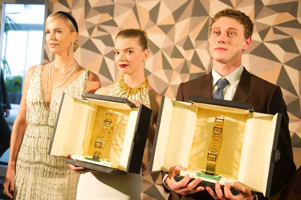 Anya Taylor-Joy and George MacKay receiving the 2017 Chopard Trophy from Charlize Theron