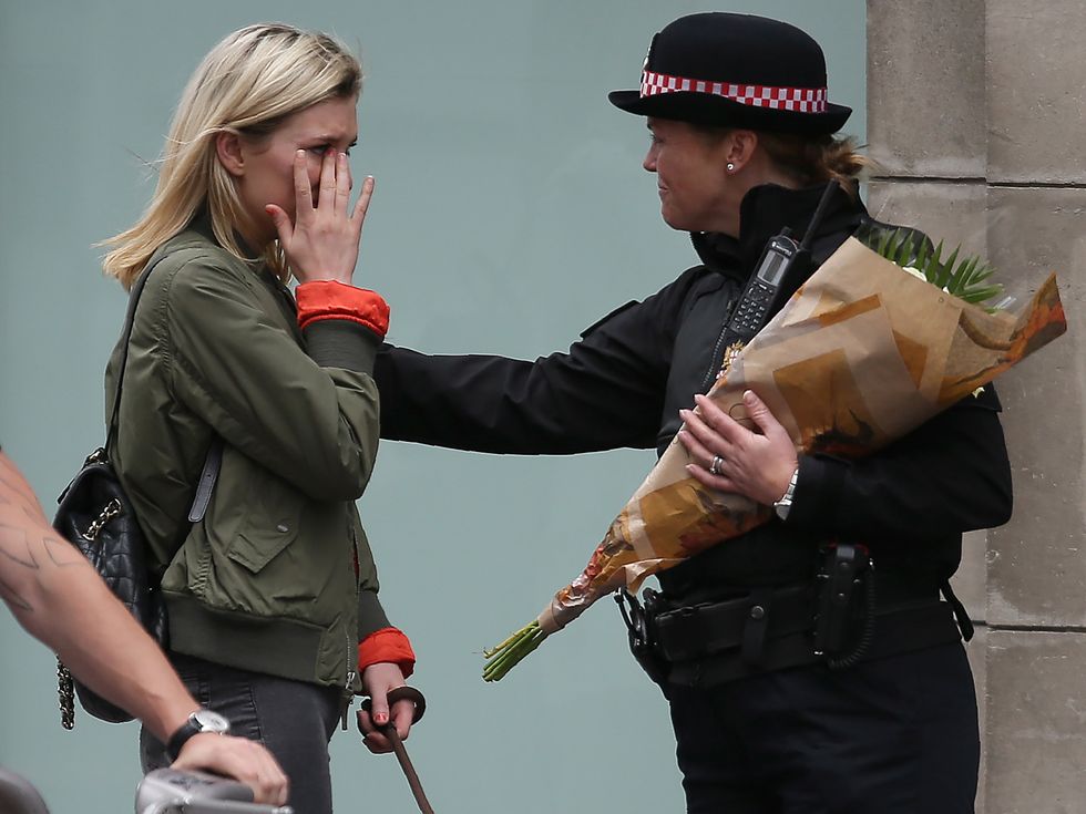 A woman brings flowers to the scene of Saturday's terror attack