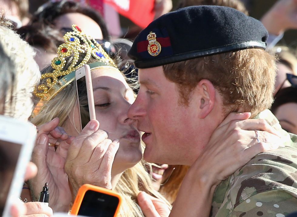 Prince Harry gets kissed by Royal Fan Victoria McRae during a walkabout outside the Sydney Opera House on May 7, 2015 in Sydney, Australia