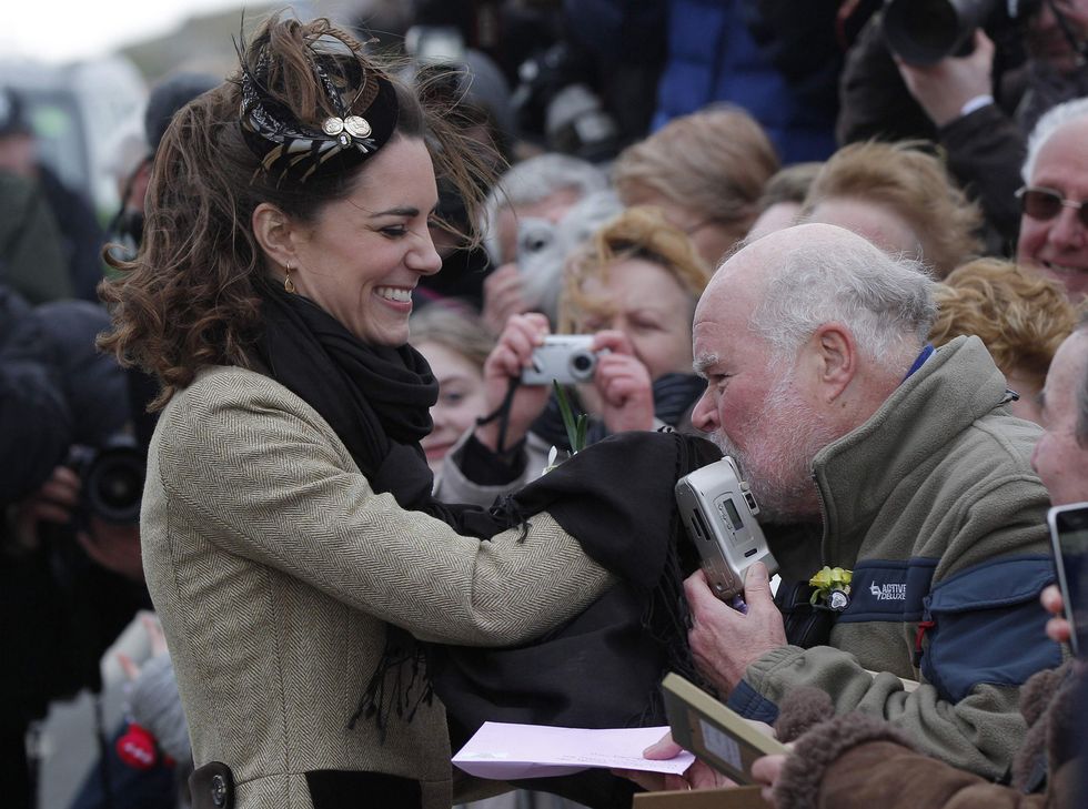 Kate Middleton has her hand kissed by a royal fan meet members of the public as they attend a naming ceremony for the new Royal National Lifeboat Institution's (RNLI) Atlantic 85 lifeboat 'Hereford Endeavour' at the RNLI Lifeboat Station in Anglesey, near Bangor in Wales, on February 24, 2011