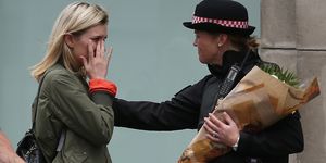 A woman brings flowers to the scene of Saturday's terror attack